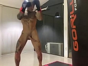 Boxeador dotado batendo no saco de pancada de pau duro